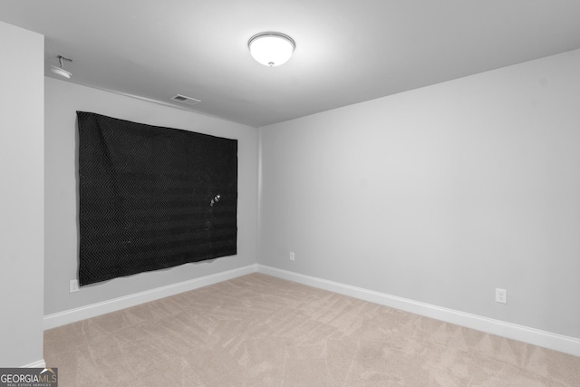 spare room with carpet floors, baseboards, and visible vents
