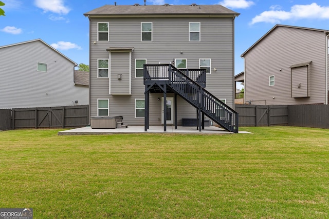 back of house with a hot tub, a fenced backyard, a patio area, and stairs