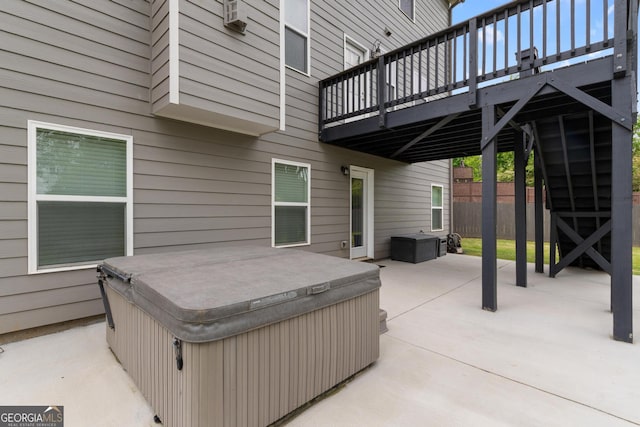 view of patio with a hot tub and a deck