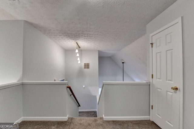 bonus room with visible vents, carpet, a textured ceiling, and baseboards