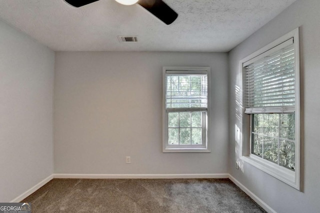 unfurnished room featuring carpet floors, baseboards, a ceiling fan, and visible vents