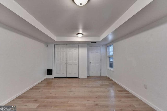 unfurnished bedroom with light wood-style floors, baseboards, and a closet