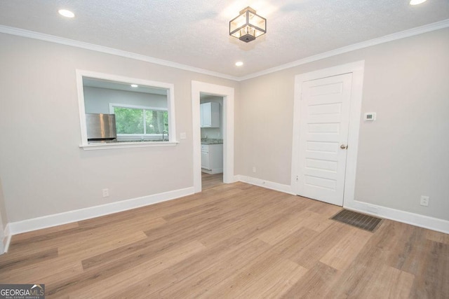 spare room featuring a textured ceiling, baseboards, recessed lighting, and light wood-style flooring