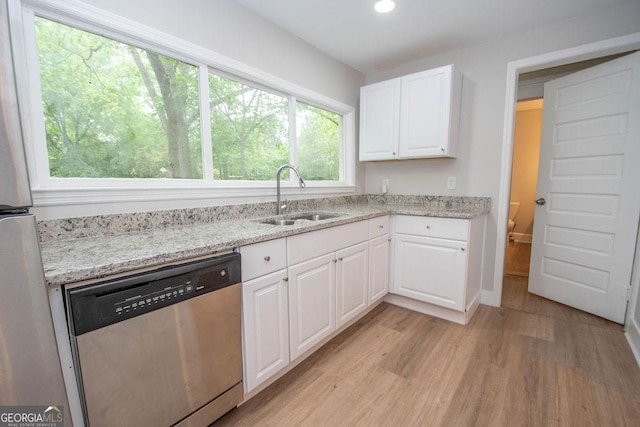 kitchen with light wood-type flooring, a sink, white cabinetry, and appliances with stainless steel finishes