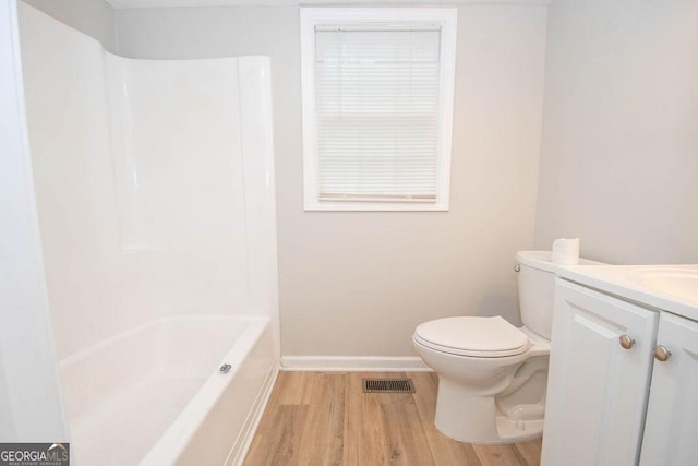 bathroom with vanity, toilet, baseboards, wood finished floors, and visible vents