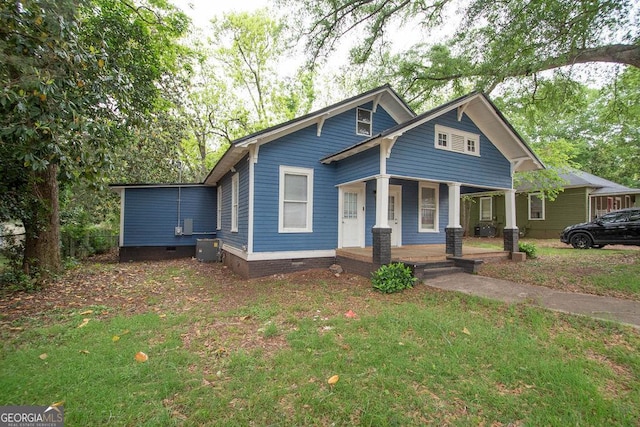 bungalow-style home featuring a porch, crawl space, central AC unit, and a front lawn
