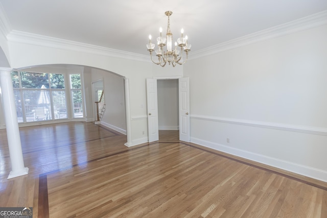5685 Commons Ln, Alpharetta, GA 30005 - unfurnished dining area featuring crown molding, arched walkways, baseboards, and light wood finished floors
