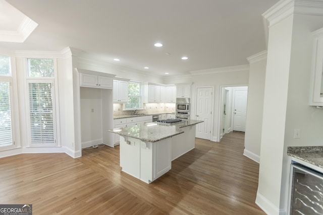 5685 Commons Ln, Alpharetta, GA 30005 - kitchen with crown molding, a kitchen island, beverage cooler, and white cabinetry