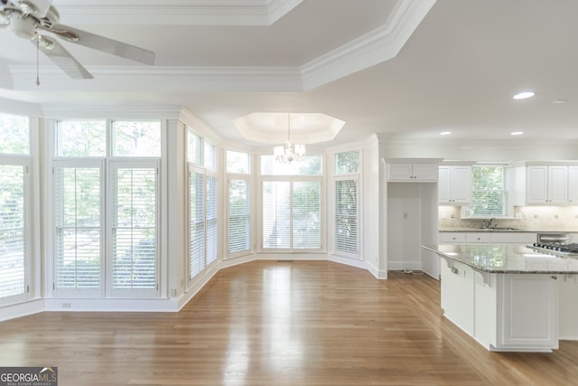 5685 Commons Ln, Alpharetta, GA 30005 - kitchen with a raised ceiling, light wood-style floors, white cabinetry, decorative backsplash, and ornamental molding