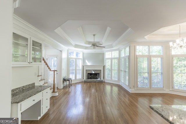 5685 Commons Ln, Alpharetta, GA 30005 - unfurnished living room featuring crown molding, stairs, a fireplace, a raised ceiling, and ceiling fan with notable chandelier