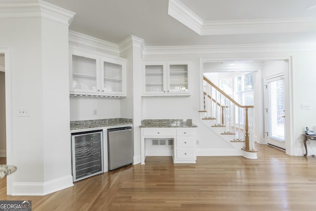 5685 Commons Ln, Alpharetta, GA 30005 - bar with ornamental molding, wood finished floors, beverage cooler, stairway, and a dry bar
