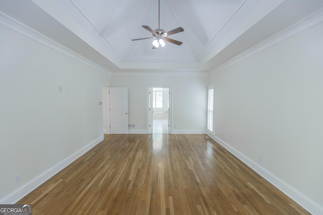 5685 Commons Ln, Alpharetta, GA 30005 - unfurnished living room featuring a ceiling fan, wood finished floors, baseboards, lofted ceiling, and a tray ceiling