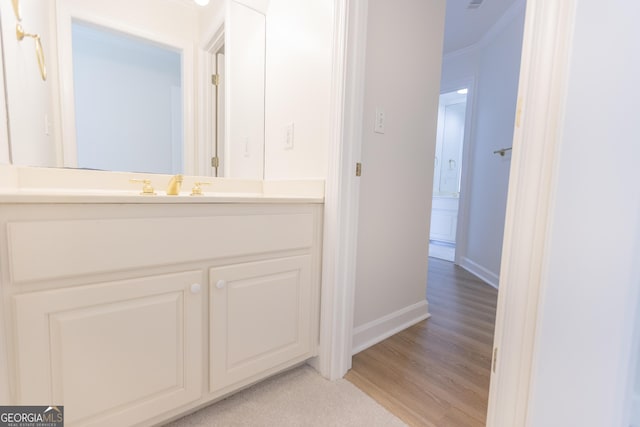 5685 Commons Ln, Alpharetta, GA 30005 - bathroom with crown molding, baseboards, vanity, and wood finished floors