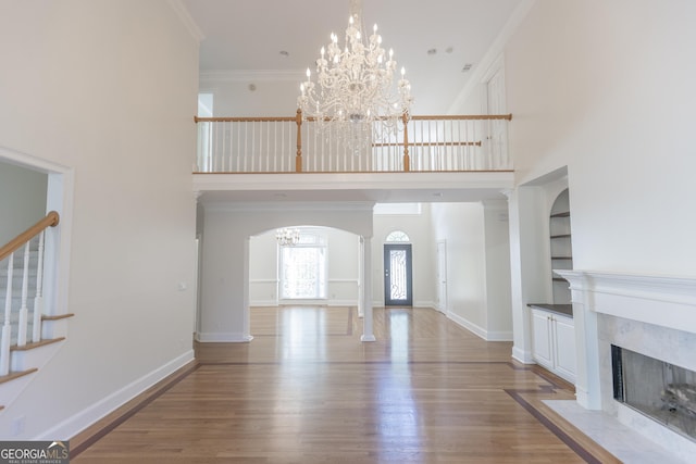 5685 Commons Ln, Alpharetta, GA 30005 - entryway with a towering ceiling, wood finished floors, stairway, arched walkways, and a notable chandelier