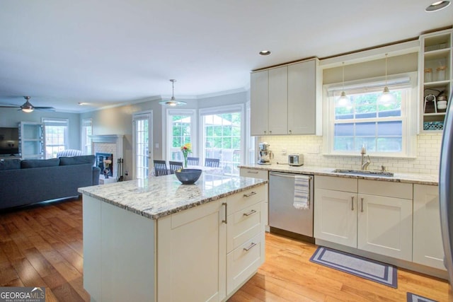 1812 Riverton Dr, Suwanee, GA 30024 - kitchen with stainless steel dishwasher, crown molding, decorative backsplash, a sink, and light wood-style flooring
