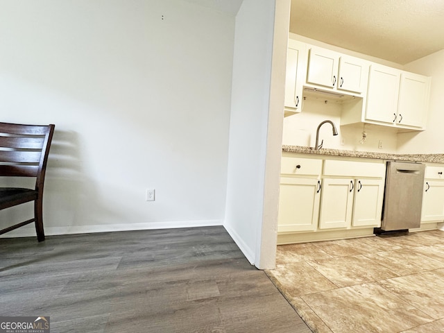 1812 Ashborough Cir SE Unit C, Marietta, GA 30067 - kitchen featuring stainless steel dishwasher, light stone countertops, baseboards, white cabinets, and light wood finished floors