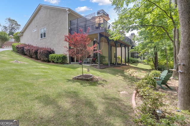 view of side of home with a lawn and stucco siding