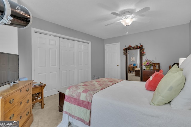 bedroom with a closet, a ceiling fan, and light carpet