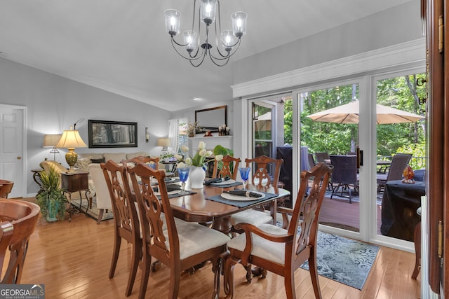 dining area with an inviting chandelier, plenty of natural light, light wood finished floors, and lofted ceiling