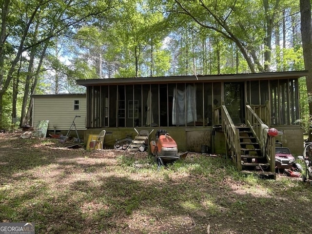 rear view of house featuring a sunroom
