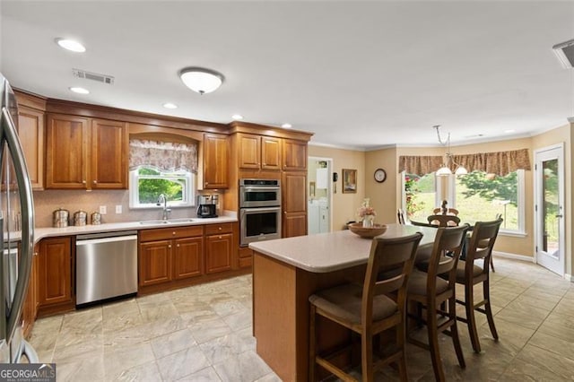122 Gold View Dr, Dahlonega, GA 30533 - kitchen featuring appliances with stainless steel finishes, a sink, brown cabinetry, washing machine and dryer, and light countertops
