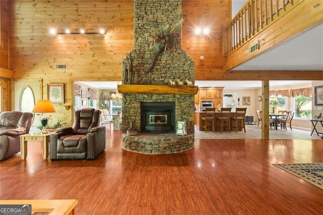 122 Gold View Dr, Dahlonega, GA 30533 - living room featuring a high ceiling, wood finished floors, a stone fireplace, and wooden walls
