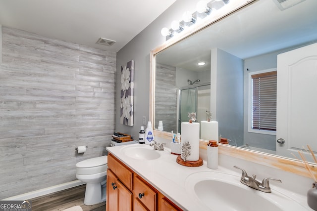 bathroom featuring visible vents, a sink, a stall shower, and toilet