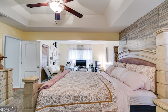 carpeted bedroom featuring a tray ceiling, visible vents, and ceiling fan
