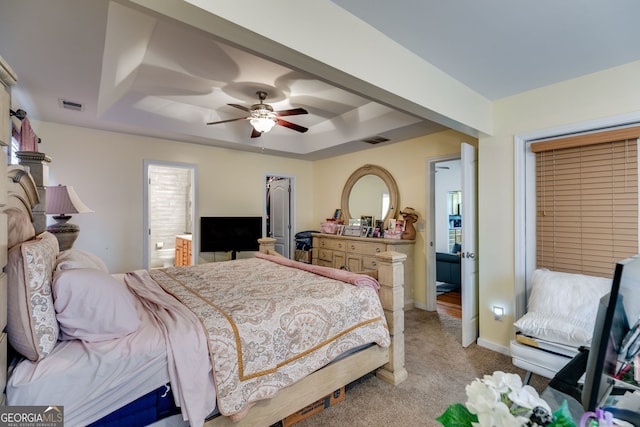 bedroom with a tray ceiling, baseboards, light colored carpet, and visible vents