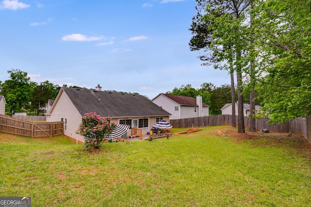 back of property featuring a fenced backyard, a patio area, and a yard