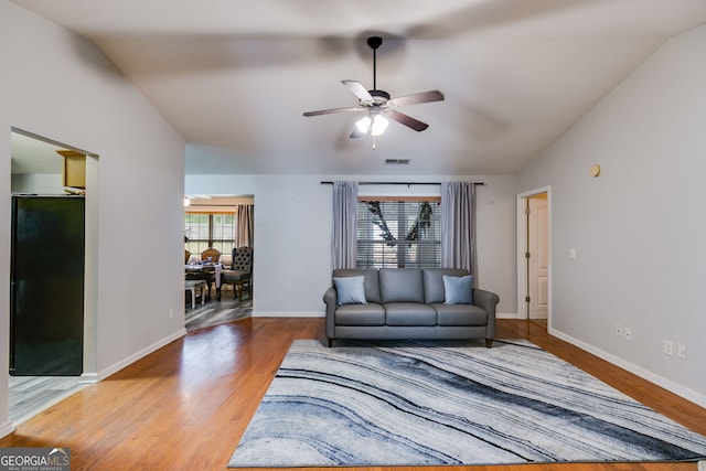 living room featuring baseboards, ceiling fan, and wood finished floors