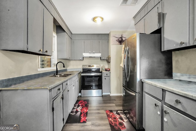 106 Vickie Dr, Warner Robins, GA 31093 - kitchen with dark wood-style flooring, under cabinet range hood, a sink, appliances with stainless steel finishes, and gray cabinetry
