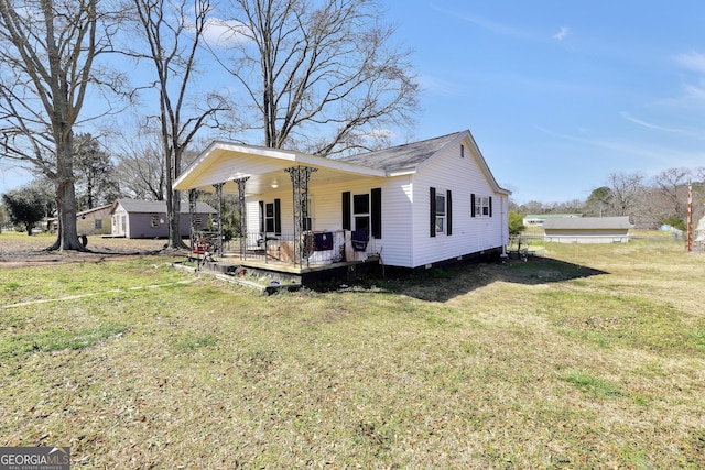 exterior space with covered porch, roof with shingles, and a front yard