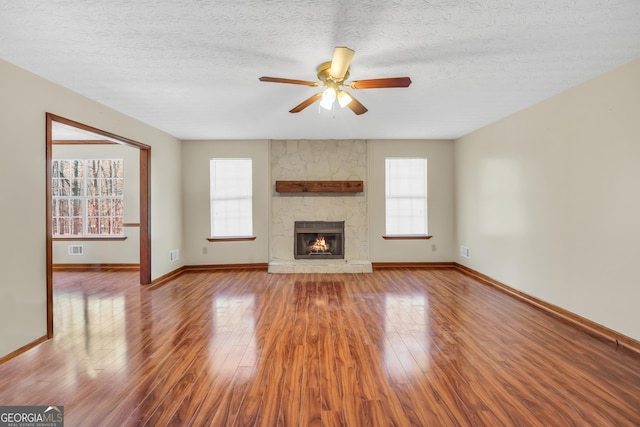 175 Laney Ct, Mcdonough, GA 30252 - unfurnished living room featuring a ceiling fan, baseboards, a healthy amount of sunlight, and wood finished floors
