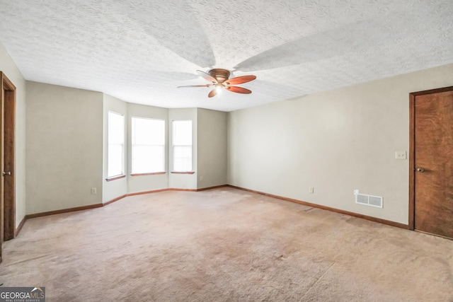 175 Laney Ct, Mcdonough, GA 30252 - spare room featuring visible vents, baseboards, ceiling fan, light colored carpet, and a textured ceiling