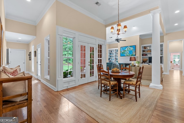 dining area with crown molding, decorative columns, light wood-style flooring, and visible vents