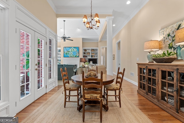 dining space featuring light wood finished floors, french doors, ceiling fan with notable chandelier, visible vents, and ornamental molding