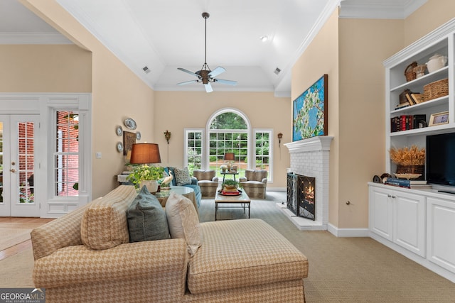 living area with a ceiling fan, visible vents, a fireplace, high vaulted ceiling, and light carpet