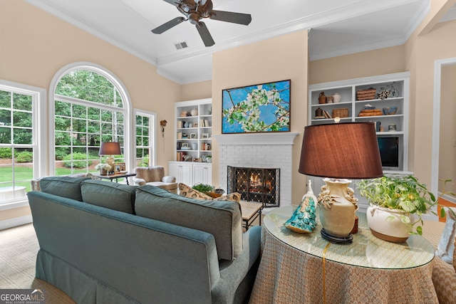 living room with visible vents, crown molding, ceiling fan, and a fireplace