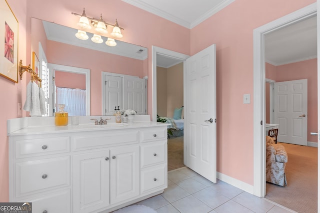 bathroom featuring tile patterned flooring, vanity, baseboards, ornamental molding, and ensuite bathroom