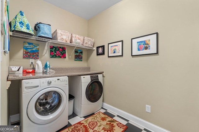 washroom featuring baseboards, laundry area, washer and clothes dryer, and tile patterned floors