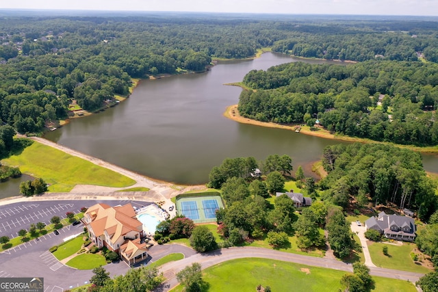 bird's eye view with a water view and a wooded view