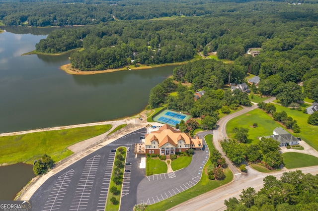 drone / aerial view featuring a water view and a wooded view