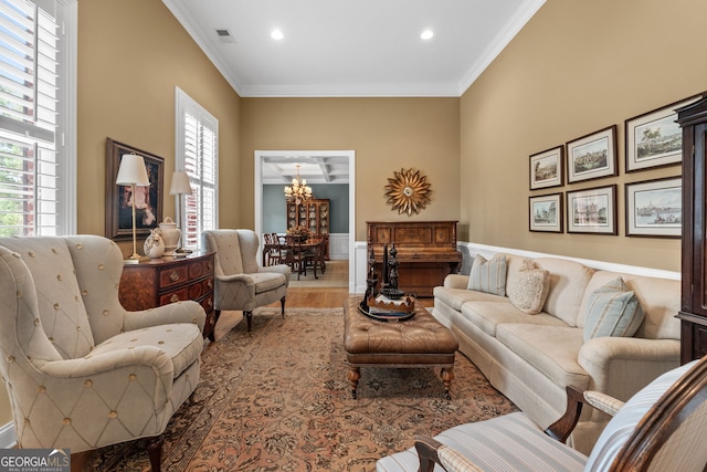 living area featuring visible vents, crown molding, wood finished floors, an inviting chandelier, and recessed lighting
