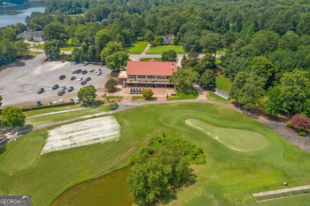 birds eye view of property with a water view, a view of trees, and golf course view