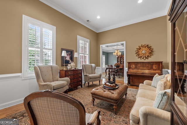 living area with crown molding, wood finished floors, baseboards, a notable chandelier, and recessed lighting