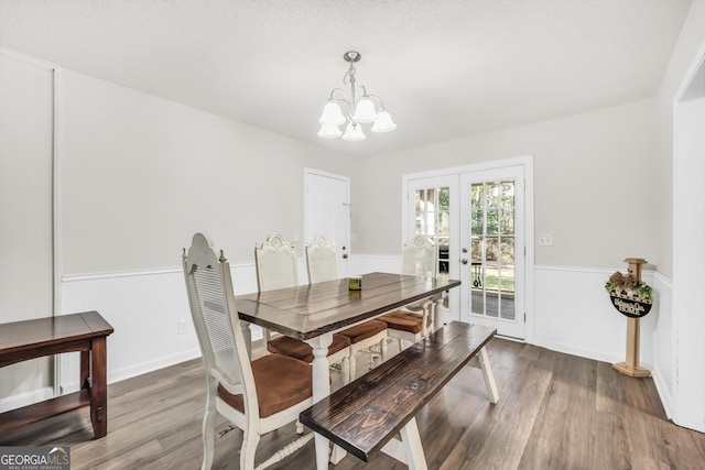 dining space featuring an inviting chandelier, wood finished floors, and french doors