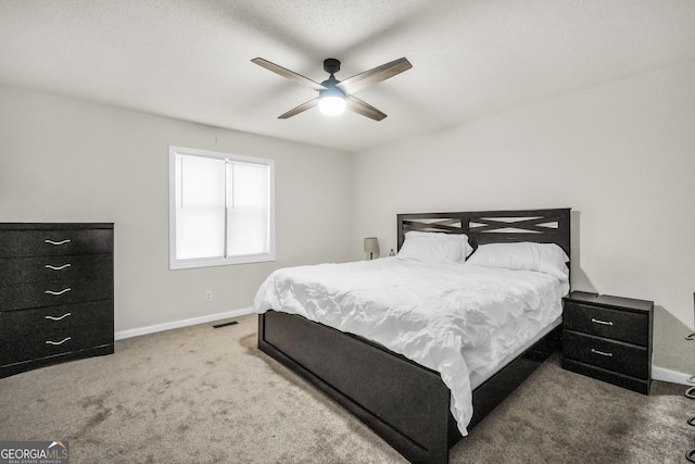 carpeted bedroom with a ceiling fan, baseboards, and visible vents