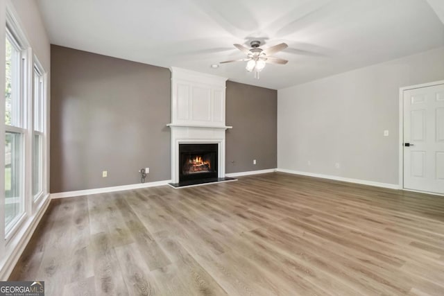 1931 Abinger Way, Lawrenceville, GA 30043 - unfurnished living room featuring baseboards, ceiling fan, light wood-style flooring, and a fireplace