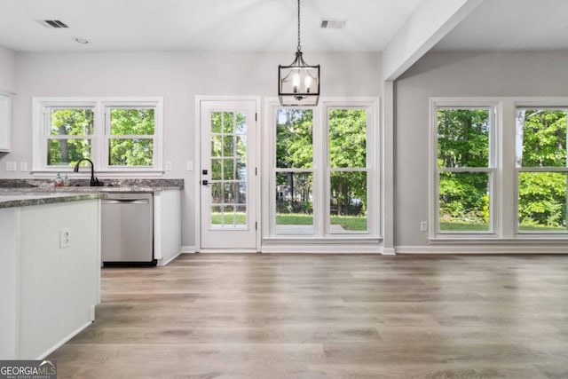 1931 Abinger Way, Lawrenceville, GA 30043 - unfurnished dining area featuring a healthy amount of sunlight, a notable chandelier, and visible vents